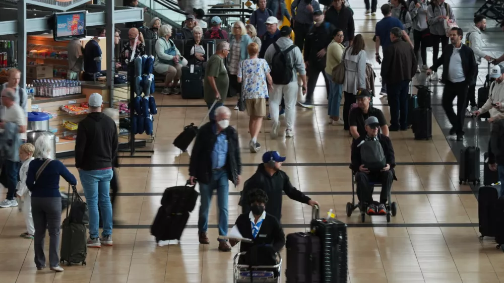 People make their way through a terminal at San Diego International Airport Saturday, Nov. 8, 2025, in San Diego. (AP Photo/Gregory Bull)