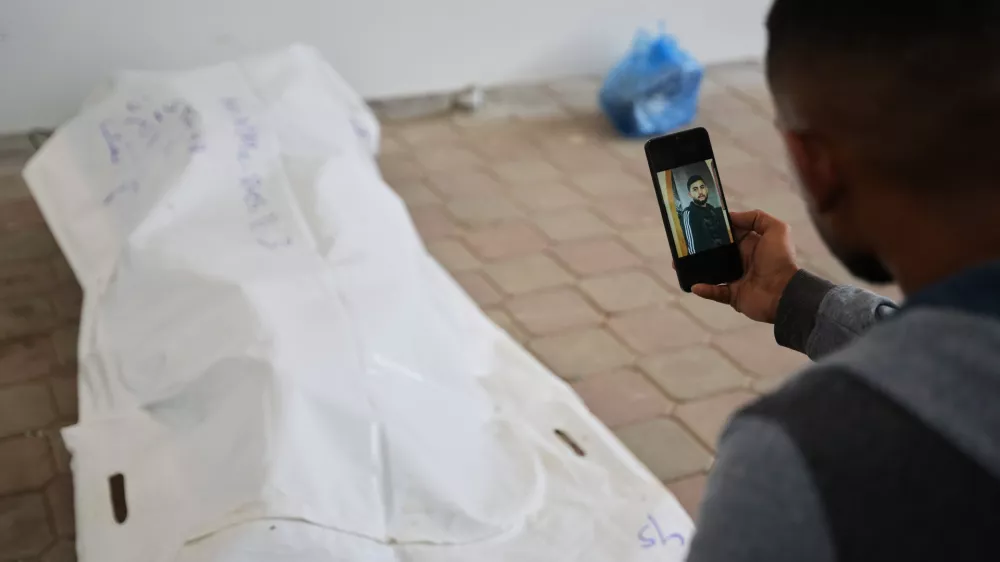 A relative shows a photo of Rami Assaf after his body was identified by his family. His remains were returned from Israel as part of the cease-fire deal and brought to Nasser Hospital in Khan Younis, Gaza Strip, Saturday, Nov. 8, 2025. (AP Photo/Abdel Kareem Hana)