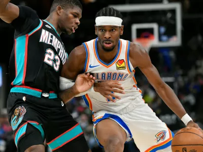 Oklahoma City Thunder guard Shai Gilgeous-Alexander, right, handles the ball against Memphis Grizzlies forward Cedric Coward (23) in the second half of an NBA basketball game Sunday, Nov. 9, 2025, in Memphis, Tenn. (AP Photo/Brandon Dill)
