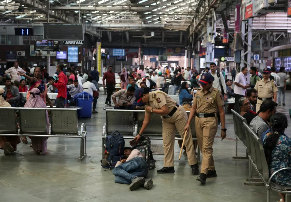 Mumbai police inspect a sleeping man during a patrol after heightened security following an explosion in New Delhi, at a railway station in Mumbai, India, November 11, 2025. REUTERS/Francis Mascarenhas