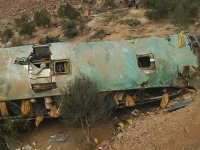 In this photo provided by the government news agency Andina, a crashed bus lays on the bottom of a cliff in Arequipa, Peru, Wednesday, Feb. 21, 2018. At least 25 people were killed when their bus veered off a highway and tumbled 200 meters down a cliff. (Andina News Agency via AP)