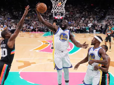Golden State Warriors forward Draymond Green (23) grabs a rebound in front of San Antonio Spurs forward Harrison Barnes (40) during the first half of an NBA basketball game in San Antonio, Wednesday, Nov. 12, 2025. (AP Photo/Eric Gay)