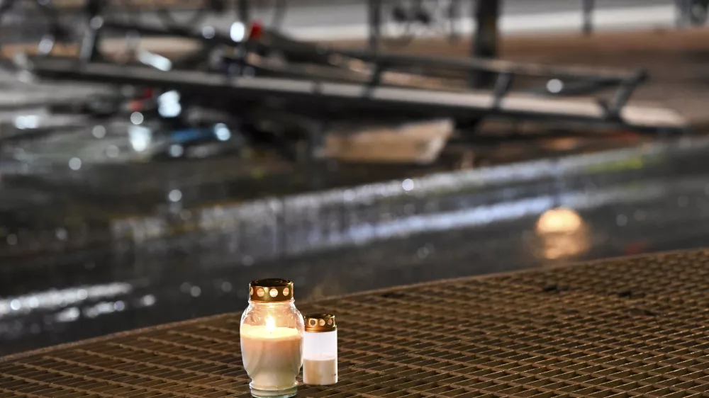 Candles for victims sit at the scene of the accident after a bus crashed into a bus stop in &Ouml;stermalm in Stockholm, Sweden, Friday. Nov. 14, 2025. (Henrik Montgomery/TT News Agency via AP)