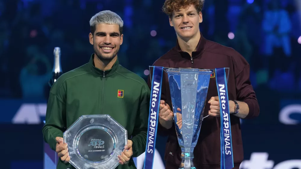 Spain's Carlos Alcaraz, left, and winner Italy's Jannik Sinner stand on the podium after the final tennis match of the ATP World Tour Finals, in Turin, Italy, Sunday, Nov. 16, 2025. (AP Photo/Antonio Calanni)