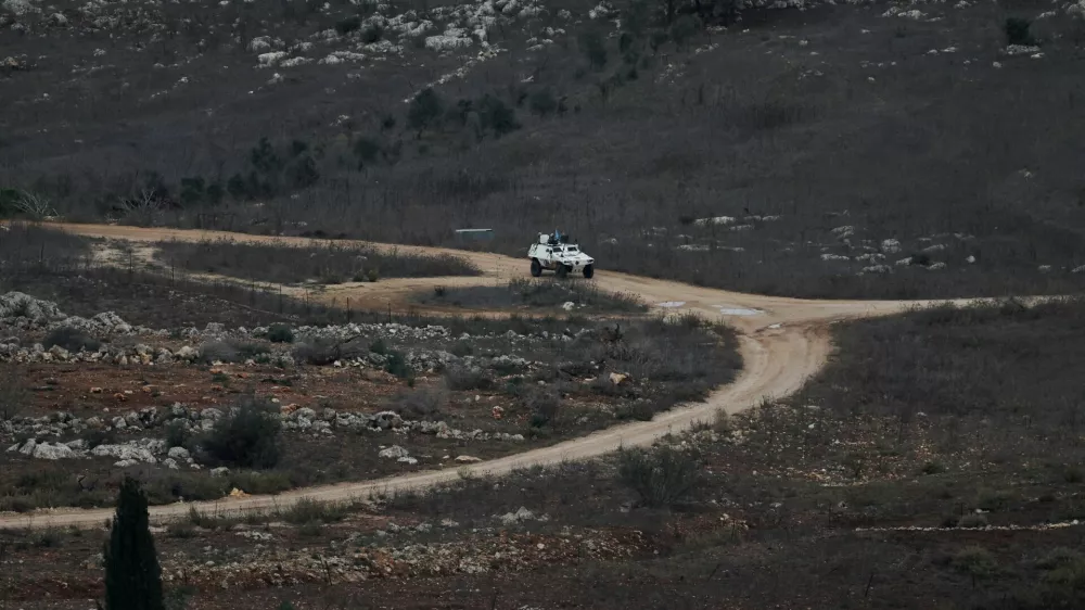 A UN vehicle drives near a concrete wall along Lebanon's southern border which, according to the Lebanese presidency, extends beyond the "Blue Line", a U.N.-mapped line separating Lebanon from Israel and the Israeli-occupied Golan Heights, as seen from northern Israel, November 16, 2025. REUTERS/Shir Torem