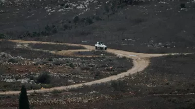 A UN vehicle drives near a concrete wall along Lebanon's southern border which, according to the Lebanese presidency, extends beyond the "Blue Line", a U.N.-mapped line separating Lebanon from Israel and the Israeli-occupied Golan Heights, as seen from northern Israel, November 16, 2025. REUTERS/Shir Torem