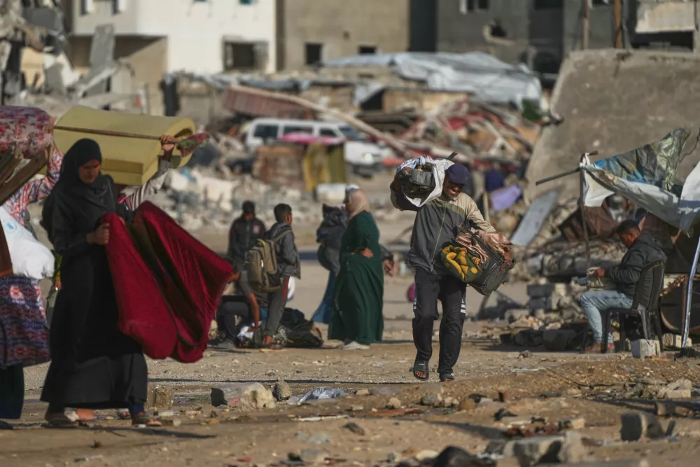 A Palestinian man carries bags of firewood after collecting them from the rubbish in Khan Younis, southern Gaza Strip, on Saturday, Nov. 15, 2025. (AP Photo/Abdel Kareem Hana)