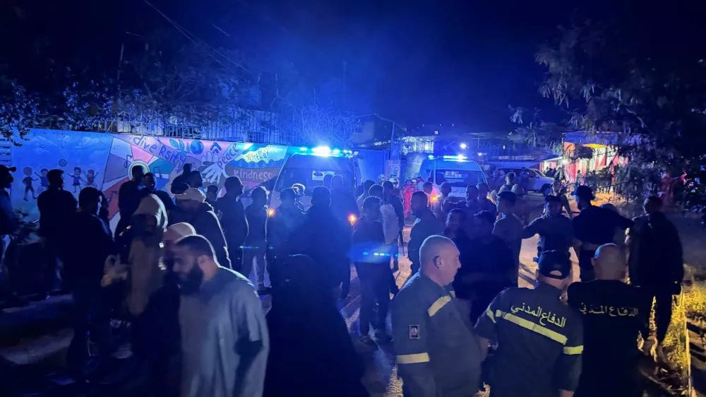 People and civil defence members gather at the entrance of Ain al-Hilweh Palestinian refugee camp, following an Israeli strike that killed several people, according to the Lebanese Health Ministry, in the southern city of Sidon, Lebanon November 18, 2025. REUTERS/Ali Hankir