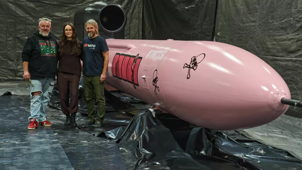 Jan Polak, right, and Martin Ondracek, left, from the Czech organization, Weapons to Ukraine, together with Iryna Terekh, Chief Technology Officer of the Fire Point factory, center, pose for photo by a Flamingo cruise missile, which was paid for by Czech crowdfunding campaign, at the Fire Point factory at an undisclosed location in Ukraine, Sunday, Nov. 16, 2025. (AP Photo/Efrem Lukatsky) / Foto: Efrem Lukatsky