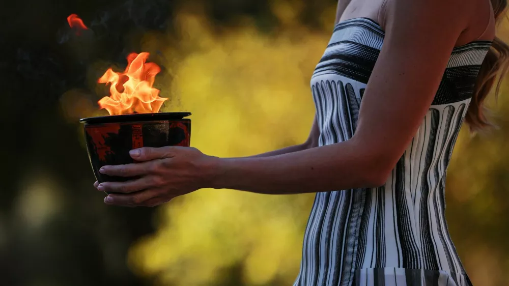 Olympics - 2026 Milano-Cortina Winter Olympics - Dress rehearsal of the Olympics Flame Lighting Ceremony - Ancient Olympia, Greece - November 24, 2025 A performer in the role of a Priestess, carries the Olympic flame during the dress rehearsal ahead of the ceremony REUTERS/Louisa Gouliamaki / Foto: Louisa Gouliamaki