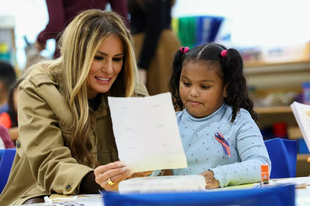 U.S. first lady Melania Trump interacts with a girl during her and second lady Usha Vance's visit to an elementary school at Marine Corps Base Camp Lejeune in Jacksonville, North Carolina, U.S., November 19, 2025. REUTERS/Kevin Lamarque
