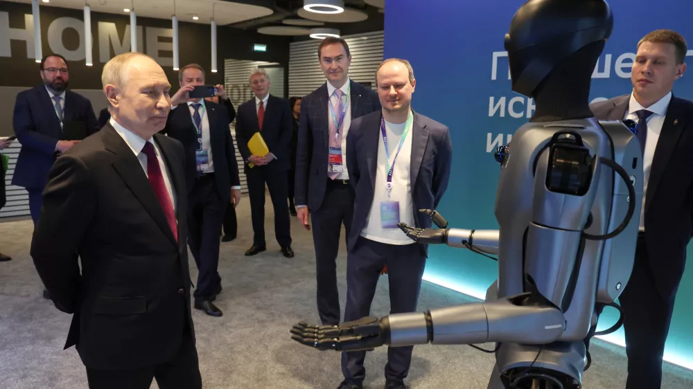 Russian President Vladimir Putin, left, looks at a humanoid robot with built-in Sberbank's GigaChat as he visits an exhibition of the AI Journey&nbsp;2025, an international conference on artificial intelligence and machine learning, at the Sberbank City business complex in Moscow, Russia, Wednesday, Nov. 19, 2025. (Vyacheslav Prokofyev, Sputnik, Kremlin Pool Photo via AP)