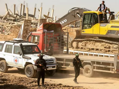 Hamas militants escort members of the Red Cross towards an area within the so-called "yellow line" to which Israeli troops withdrew under the ceasefire, as Hamas says it continues to search for the bodies of deceased hostages seized during the October 7, 2023, attack on Israel, in Gaza City November 20, 2025. REUTERS/Dawoud Abu Alkas