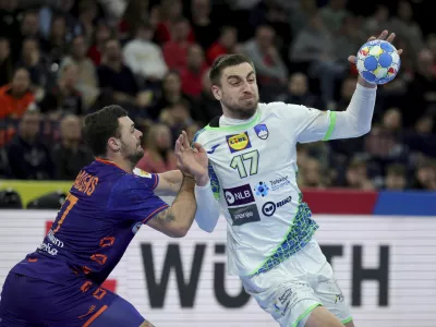 Slovenia's Nejc Cehte and Dani Baijens from the Netherlands, left, in action during the Handball European Championship main round, group 2 match between Slovenia and Netherlands in Hamburg, Germany, Sunday Jan. 21, 2024. (Christian Charisius/dpa via AP)