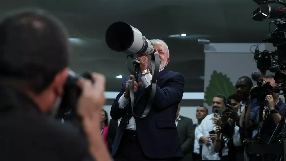 Brazil's President Luiz Inacio Lula da Silva holds a camera lens during the UN Climate Change Conference (COP30), in Belem, Brazil, November 19, 2025. REUTERS/Adriano Machado