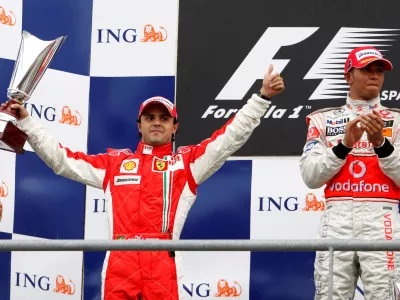 FILE PHOTO: Ferrari Formula One driver Felipe Massa (L) puts a thumb up while standing on the podium next to McLaren Formula One driver Lewis Hamilton of Britain (R) after the Belgian Grand Prix at the Spa-Francorchamps race track September 7, 2008. REUTERS/Yves Herman (BELGIUM)/File Photo