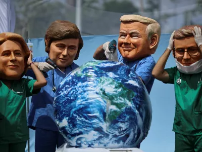 Oxfam activists wearing big head masks depicting world leaders stage a mock emergency room scene symbolizing a dying Planet Earth to call for urgent climate action during the UN Climate Change Conference (COP30), in Belem, Brazil, November 20, 2025. REUTERS/Adriano Machado   TPX IMAGES OF THE DAY