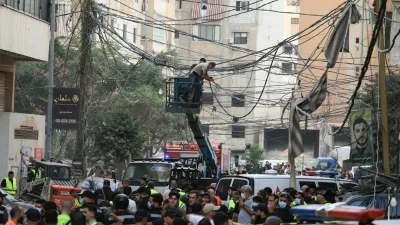 Civil defence members work as people gather near the site of an Israeli strike, after Israeli military said on Sunday that it struck a militant from the Lebanese Iran-aligned Hezbollah group, in Beirut's southern suburbs, Lebanon November 23, 2025. REUTERS/Mohamed Azakir