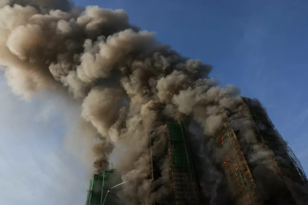 Smoke rises as flames engulf bamboo scaffolding across multiple buildings at Wang Fuk Court housing estate, in Tai Po, Hong Kong, China, November 26, 2025. REUTERS/Tyrone Siu
