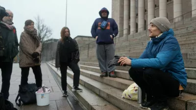 Juho-Pekka Palomaa, 33, sits on the steps in front of the Finnish parliament where he was holding a potluck protest to mark 1000 days of unemployment, in Helsinki, Finland, October 30, 2025. REUTERS/Tom Little