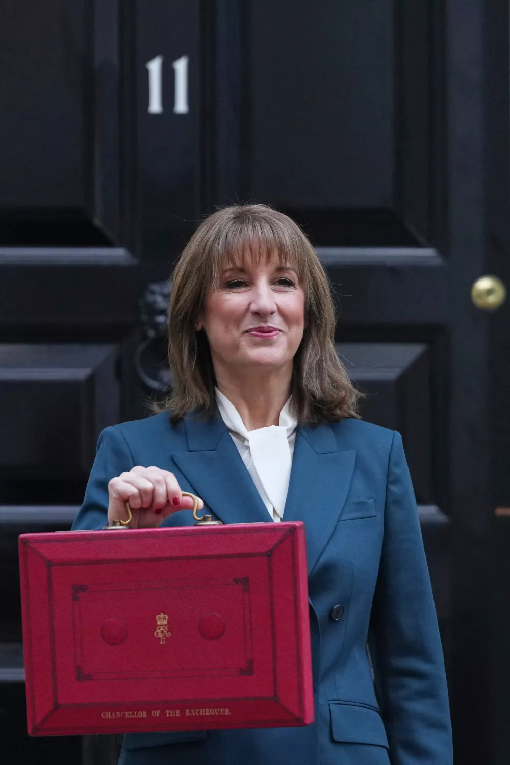 Britain's Chancellor of the Exchequer Rachel Reeves poses on the doorstep of 11 Downing Street with her ministerial red box before heading to the House of Commons to deliver her Budget speech in London, Wednesday, Nov. 26, 2025. (AP Photo/Kirsty Wigglesworth)