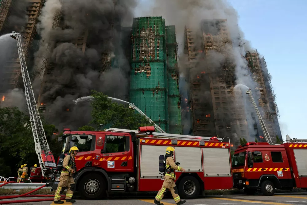 Firefighters work as efforts are underway to extinguish flames engulfing bamboo scaffolding across multiple buildings at the Wang Fuk Court housing estate in Tai Po, Hong Kong, China, November 26, 2025. REUTERS/Tyrone Siu   TPX IMAGES OF THE DAY