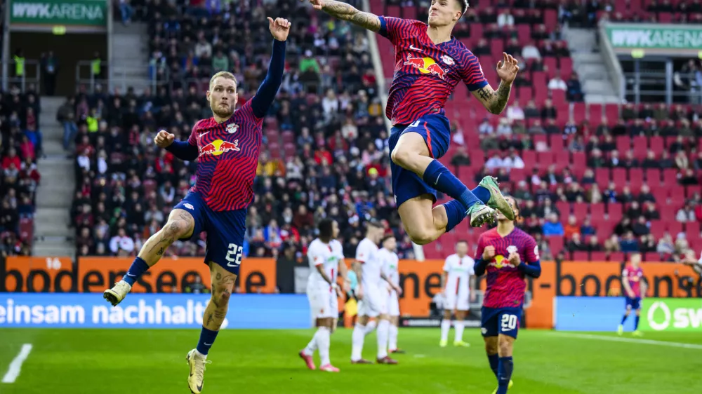 obrezek za pasico - Benjamin &Scaron;e&scaron;ko10 February 2024, Bavaria, Augsburg: Leipzig's Benjamin Sesko (R) celebrates with Leipzig's David Raum (L) after his goal during the German Bundesliga soccer match between FC Augsburg and RB Leipzig at WWK-Arena. Photo: Tom Weller/dpa - WICHTIGER HINWEIS: Gem&auml;&szlig; den Vorgaben der DFL Deutsche Fu&szlig;ball Liga bzw. des DFB Deutscher Fu&szlig;ball-Bund ist es untersagt, in dem Stadion und/oder vom Spiel angefertigte Fotoaufnahmen in Form von Sequenzbildern und/oder video&auml;hnlichen Fotostrecken zu verwerten bzw. verwerten zu lassen.
