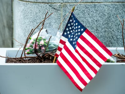 Flowers and an American flag, placed at the scene a day after two National Guard soldiers were shot near the White House in Washington, Thursday, Nov. 27, 2025. (AP Photo/Cliff Owen)