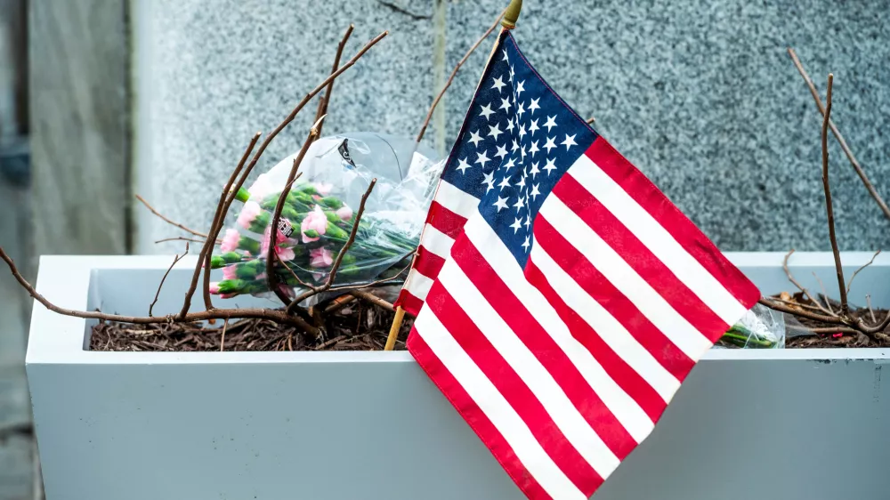 Flowers and an American flag, placed at the scene a day after two National Guard soldiers were shot near the White House in Washington, Thursday, Nov. 27, 2025. (AP Photo/Cliff Owen)