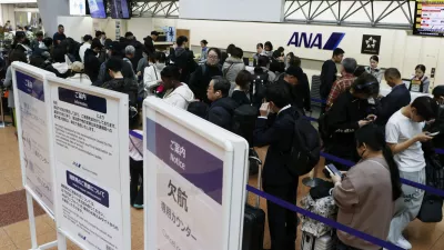 Passengers wait in line at All Nippon Airways' counter at Haneda airport in Tokyo Saturday, Nov. 29, 2025. A sign, right, reads " Flight cancellation counter." (Takahiko Kanbara/Kyodo News via AP)