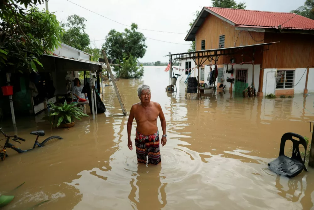 A man looks over his house compound, which is submerged under floodwaters after heavy rain in Malaysia's northern states bordering Thailand, in Kangar, Malaysia November 27, 2025. REUTERS/Hasnoor Hussain