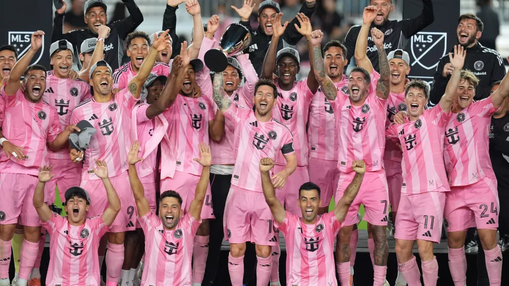 Inter Miami forward Lionel Messi (10) lifts the trophy as Inter Miami players celebrate winning an MLS Eastern Conference final soccer match against New York City FC, Saturday, Nov. 29, 2025, in Fort Lauderdale, Fla. (AP Photo/Rebecca Blackwell)