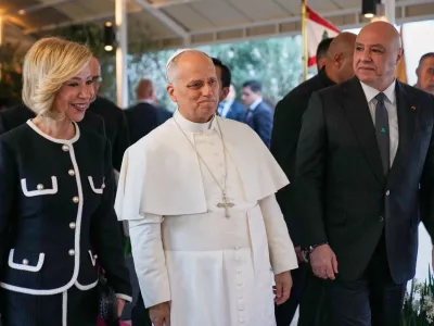 Pope Leo XIV, center, is escorted by Lebanese President Joseph Aoun, right, and First Lady Nehmat Aoun after his arrival at Beirut International Airport in Beirut, Lebanon, Sunday, Nov. 30, 2025.(AP Photo/Hussein Malla)