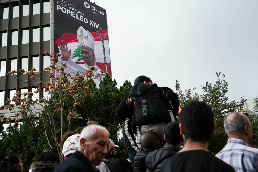 A banner featuring an image of Pope Leo XIV and the Lebanese flag hangs on a building as people wait for the Pope's arrival during his first apostolic journey, in Baabda, Lebanon, November 30, 2025. REUTERS/Raghed Waked