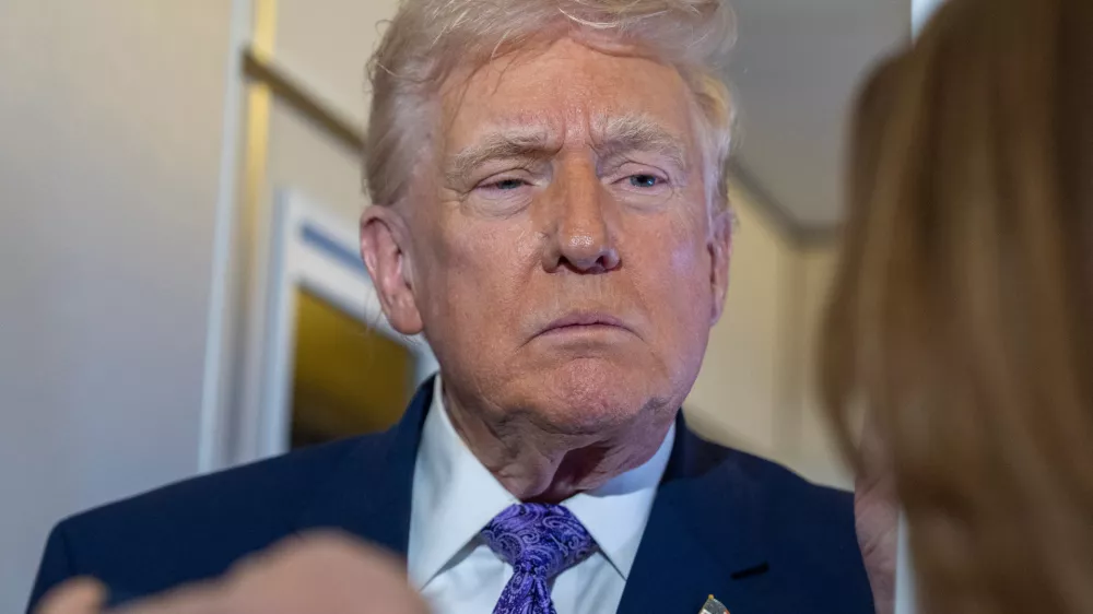 President Donald Trump speaks with reporters while in flight on Air Force One from his Mar-a-Lago estate in Palm Beach, Fla., to Joint Base Andrews, Sunday, Nov. 30, 2025. (AP Photo/Alex Brandon)