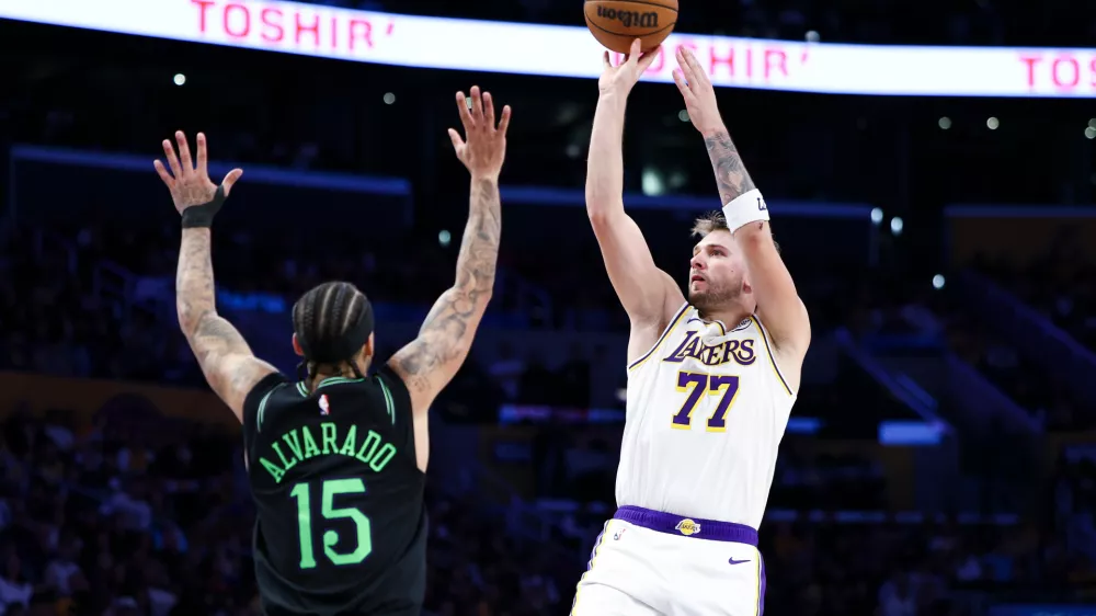 Los Angeles Lakers guard Luka Doncic (77) shoots against New Orleans Pelicans guard Jose Alvarado (15) during the second half of an NBA basketball game, Sunday, Nov. 30, 2025, in Los Angeles. (AP Photo/Jessie Alcheh)