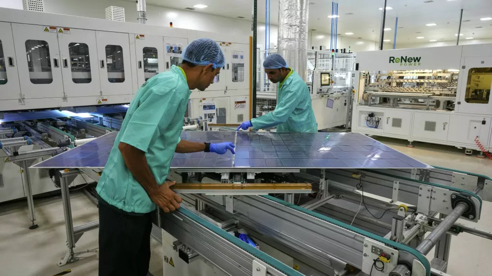 Workers check a solar panel at a ReNew manufacturing plant on the outskirts of Jaipur, India, Thursday, Aug. 21, 2025. (AP Photo/Manish Swarup)