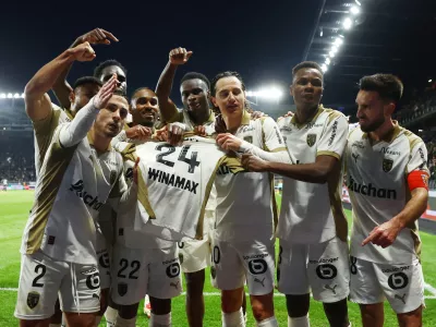 Soccer Football - Ligue 1 - Angers SCO v RC Lens - Stade Raymond Kopa, Angers, France - November 30, 2025 RC Lens' Florian Thauvin celebrates scoring their first goal with teammates by holding up Jonathan Gradit's shirt REUTERS/Stephane Mahe   TPX IMAGES OF THE DAY