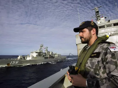Able Seaman Maritime Logistics Steward Kirk Scott keeps watch aboard the Australian Navy ship HMAS Success as they conduct a replenishment at sea with HMAS Toowoomba while continuing to search for the missing Malaysian Airlines flight MH370, in this picture released by the Australian Defence Force April 11, 2014. Search and rescue officials in Australia are confident they know the approximate position of the black box recorders from missing Malaysia Airlines Flight MH370, Australian Prime Minister Tony Abbott said on Friday. At the same time, however, the head of the agency coordinating the search said that the latest "ping" signal, which was captured by a listening device buoy on Thursday, was not related to the plane. REUTERS/Australian Defence Force/Handout via Reuters (MID-SEA - Tags: MILITARY TRANSPORT DISASTER) ATTENTION EDITORS - THIS PICTURE WAS PROVIDED BY A THIRD PARTY. REUTERS IS UNABLE TO INDEPENDENTLY VERIFY THE AUTHENTICITY, CONTENT, LOCATION OR DATE OF THIS IMAGE. THIS PICTURE IS DISTRIBUTED EXACTLY AS RECEIVED BY REUTERS, AS A SERVICE TO CLIENTS. NO SALES. NO ARCHIVES. FOR EDITORIAL USE ONLY. NOT FOR SALE FOR MARKETING OR ADVERTISING CAMPAIGNS