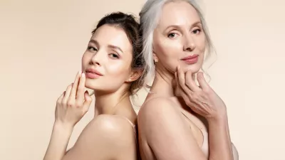 Elderly and young women with smooth skin and natural makeup standing back-to-back. Thinking, planning, dreaming