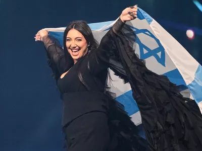 FILE - Singer Yuval Raphael, from Israel, holds the national flag during a dress rehearsal for the Grand Final of the 69th Eurovision Song Contest, May 16, 2025, in Basel, Switzerland. (AP Photo/Martin Meissner, File)