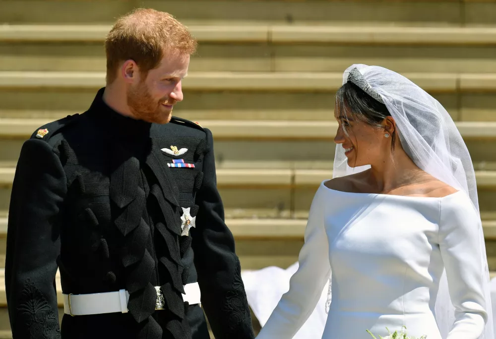 FILE - Prince Harry and Meghan Markle walk down the steps after their wedding at St. George's Chapel in Windsor Castle in Windsor, near London, England, Saturday, May 19, 2018. Britain's monarchy is bracing for more bombshells to be lobbed over the palace gates Thursday, Dec. 8, 2022 as Netflix releases the first three episodes of a series that promises to tell the "full truth" about Prince Harry and Meghan's estrangement from the royal family. (Ben Birchhall/pool photo via AP, file)