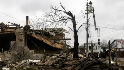 A worker of the DTEK energy company fixes power lines outside a house that was damaged during a night of Russian missile and drone strikes, amid Russia's attack on Ukraine, in Novi Petrivtsi, outside Kyiv, Ukraine, December 6, 2025. REUTERS/Thomas Peter