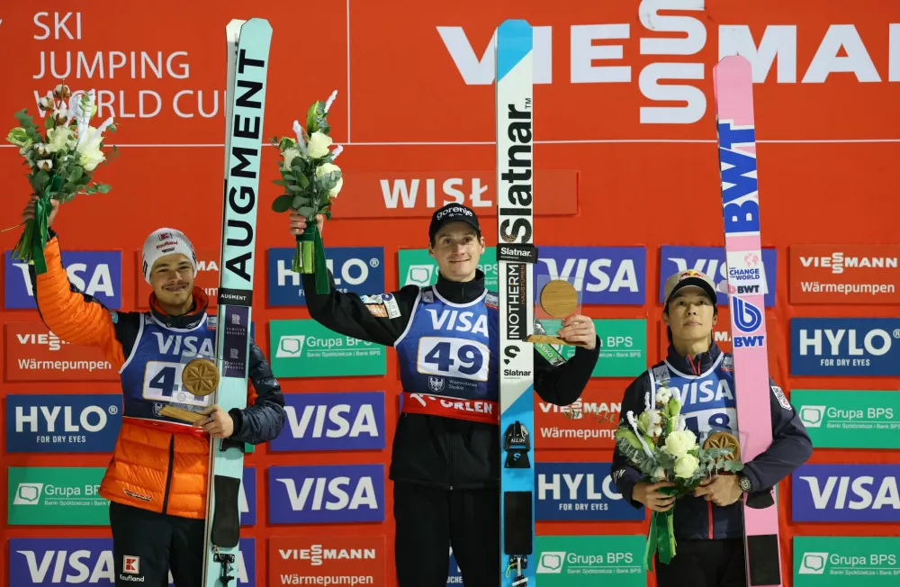 Ski Jumping - FIS Ski Jumping World Cup - Wisla, Poland - December 6, 2025 Slovenia's Domen Prevc celebrates on the podium after winning the Men's Individual Large Hill with second placed Germany's Philipp Raimund and third placed Japan's Ryoyu Kobayashi REUTERS/Kacper Pempel