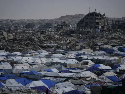 Tents sheltering displaced Palestinians stand amid the destruction left by the Israeli air and ground offensive in Gaza City Friday, Dec. 5, 2025. (AP Photo/Abdel Kareem Hana)