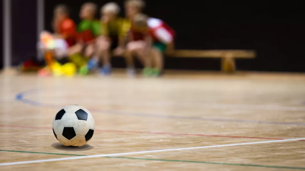 Football Futsal Ball and Youth Team. Indoor Soccer Sports Hall. Children Indoor Soccer Team. Sport Futsal background. Indoor Soccer Winter League for Kids