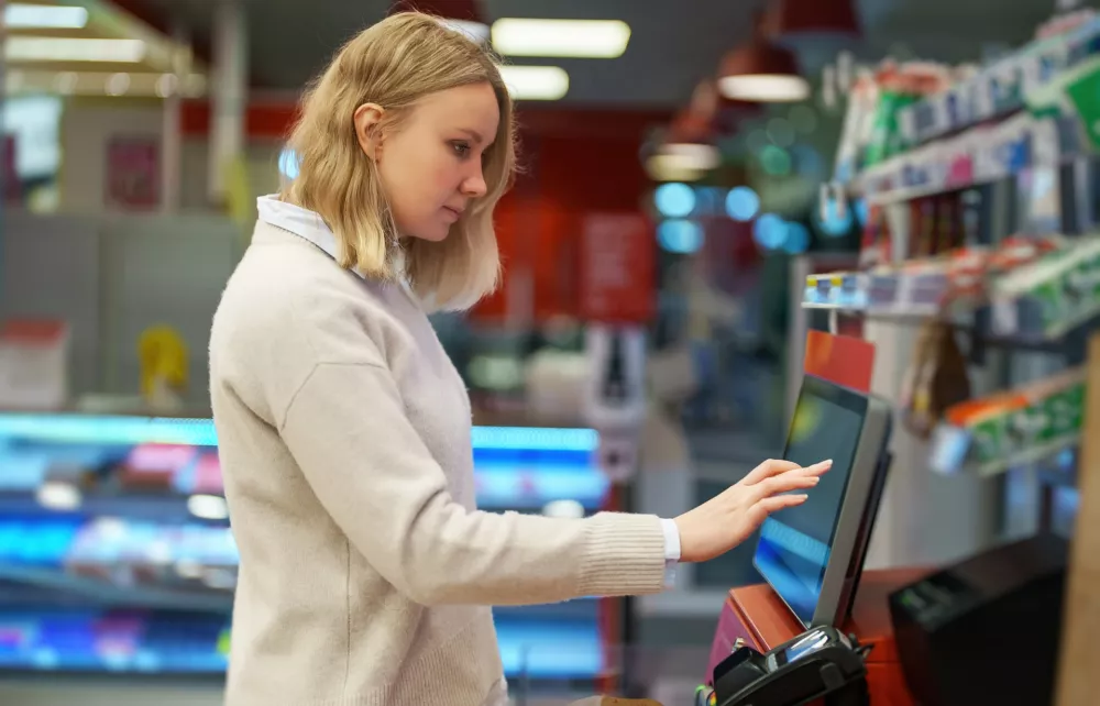 Woman pays at self-checkouts in supermarket. / Foto: M-production