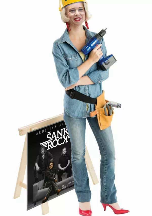 Full length portrait of beautiful female construction worker with drill standing by work horse isolated over white background / Foto: Tetmc