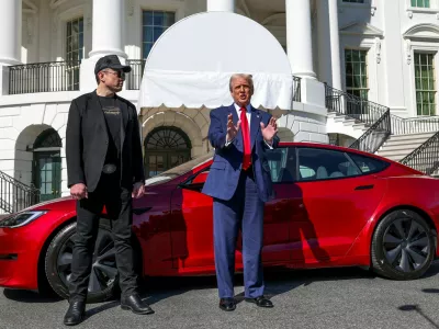 FILE PHOTO: U.S. President Donald Trump talks to the media next to Tesla CEO Elon Musk, with a Tesla car in the background, at the White House in Washington, D.C., U.S., March 11, 2025. REUTERS/Kevin Lamarque/File Photo