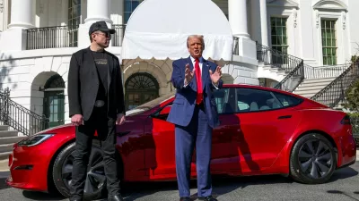 FILE PHOTO: U.S. President Donald Trump talks to the media next to Tesla CEO Elon Musk, with a Tesla car in the background, at the White House in Washington, D.C., U.S., March 11, 2025. REUTERS/Kevin Lamarque/File Photo